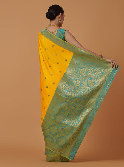 Monjolika Fashion Yellow Banarasi Silk Blend SareeWith Traditional & Modern Dulha Dulhan Figure Zari Woven Detailing