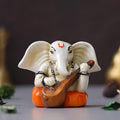 Ecraftindia White & Orange Polyresin Handcrafted Lord Ganesha Idol Playing Veena Musical Instrument