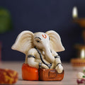 Ecraftindia White & Orange Polyresin Handcrafted Lord Ganesha Idol Playing Harmonium Musical Instrument