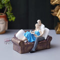 Ecraftindia Romantic Couple Statue Sitting on Sofa and Reading Book Decorative Showpiece
