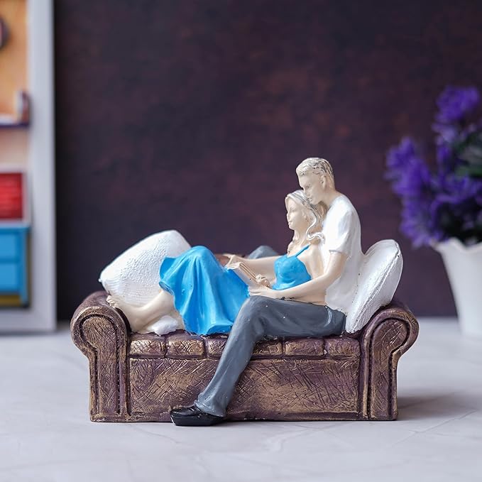Ecraftindia Romantic Couple Statue Sitting on Sofa and Reading Book Decorative Showpiece