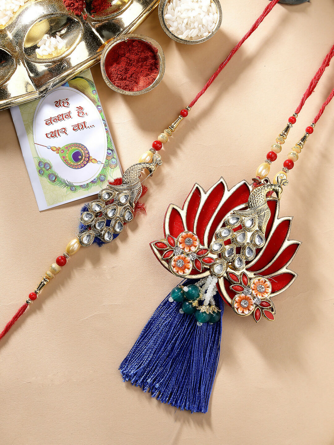NVR Women & Men Set of 2 Gold-Toned Peacock Design Stone-Studded Bhaiya Bhabhi Rakhi With Roli Chawal & Chocolate