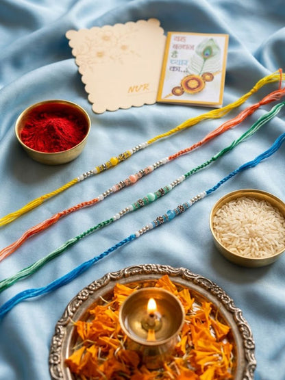NVR Set of 4 Multicolor Artificial Beads Thread Rakhi with Roli Chawal Chandan Mishri