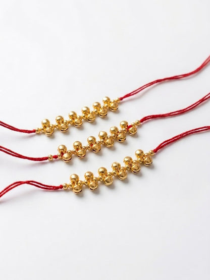 NVR Set of 3 Gold Toned Ghungroo & Red Thread Rakhi With Roli Chawal Chandan Mishri