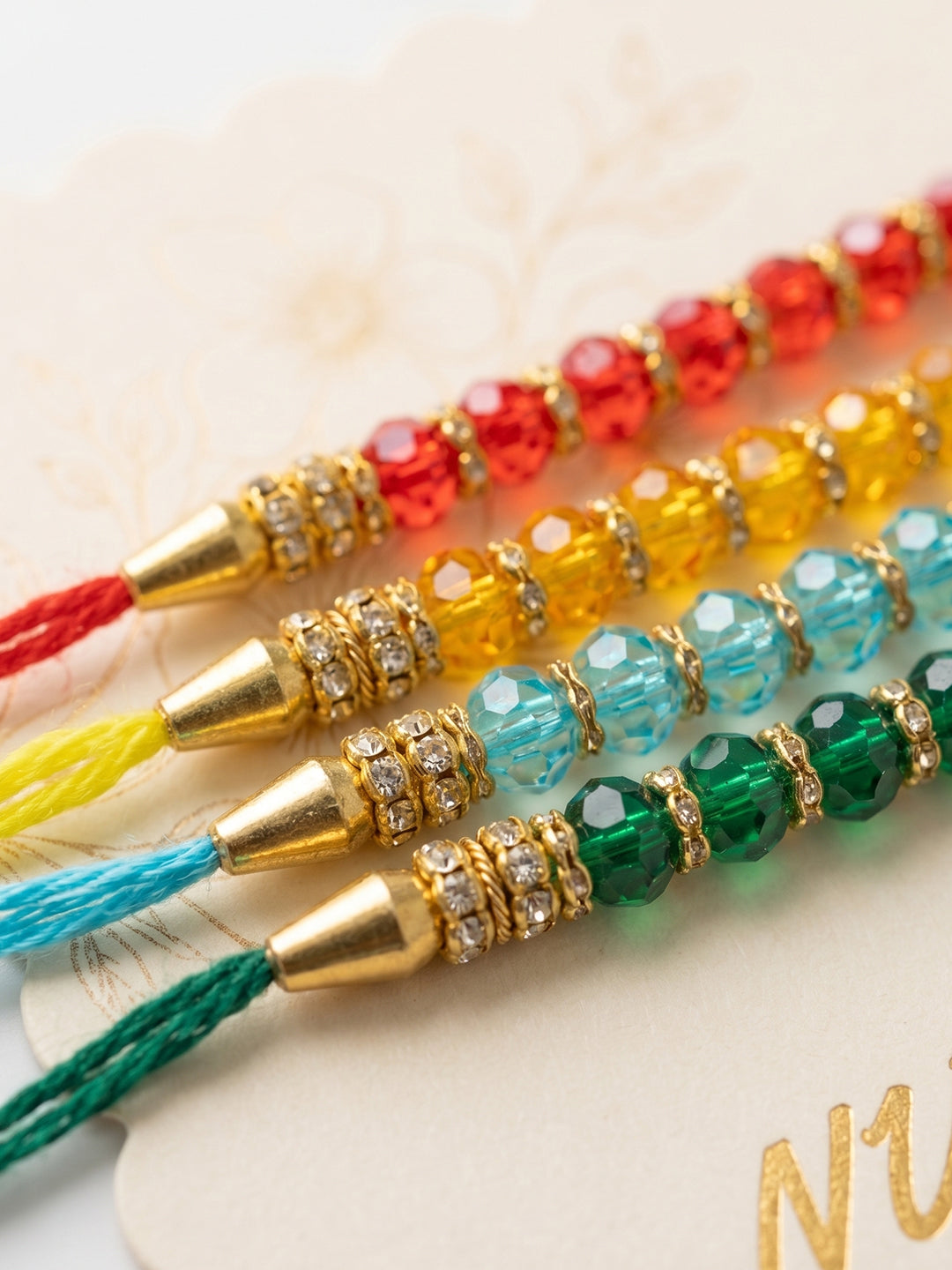 NVR Set of 4 Multicolor Artificial Beads Thread Rakhi with Roli Chawal Chandan Mishri