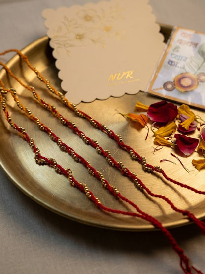 NVR Set of 4 Red & Yellow Thread Rakhi with Roli Chawal Chandan Mishri